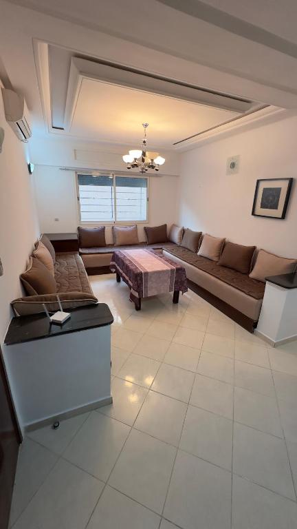 uma sala de estar com um sofá e uma mesa em Appartement familiales em Al Hoceïma