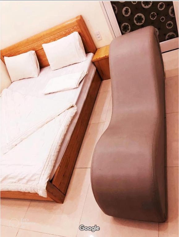 uma cama num pequeno quarto com uma estrutura em madeira em Nhà nghỉ Thành Công em Da Nang