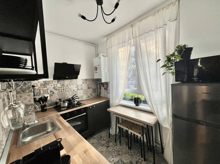 a kitchen with a sink and a table with a window at Groundfloor Rahmaninov in Bucharest