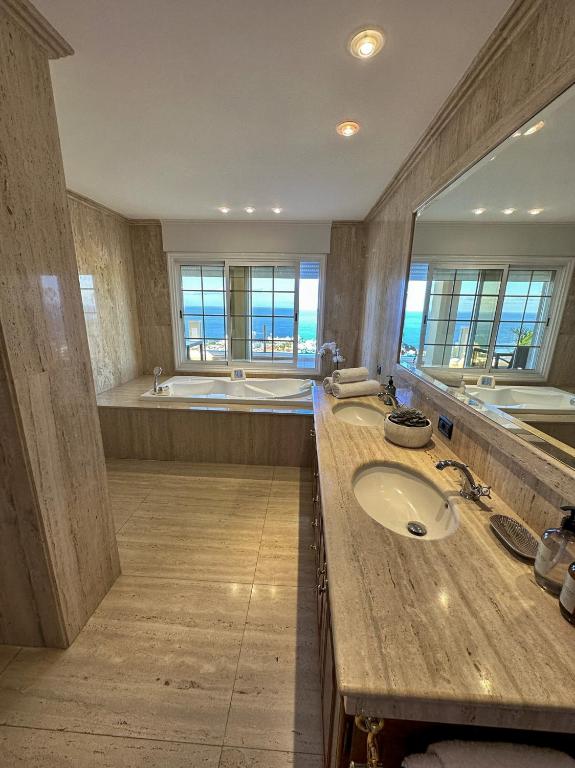 een grote badkamer met 2 wastafels en een bad bij Boutique Villa Leicht & Friends in Adeje