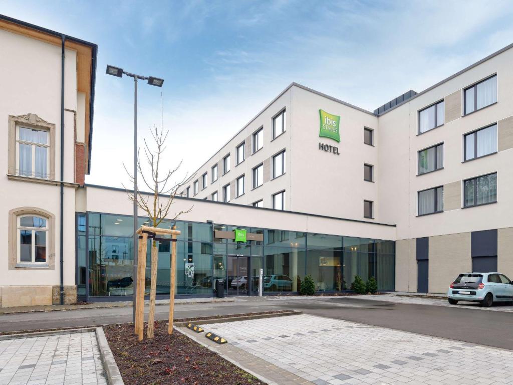 a hotel building with a tree in front of it at ibis Styles Coburg in Coburg