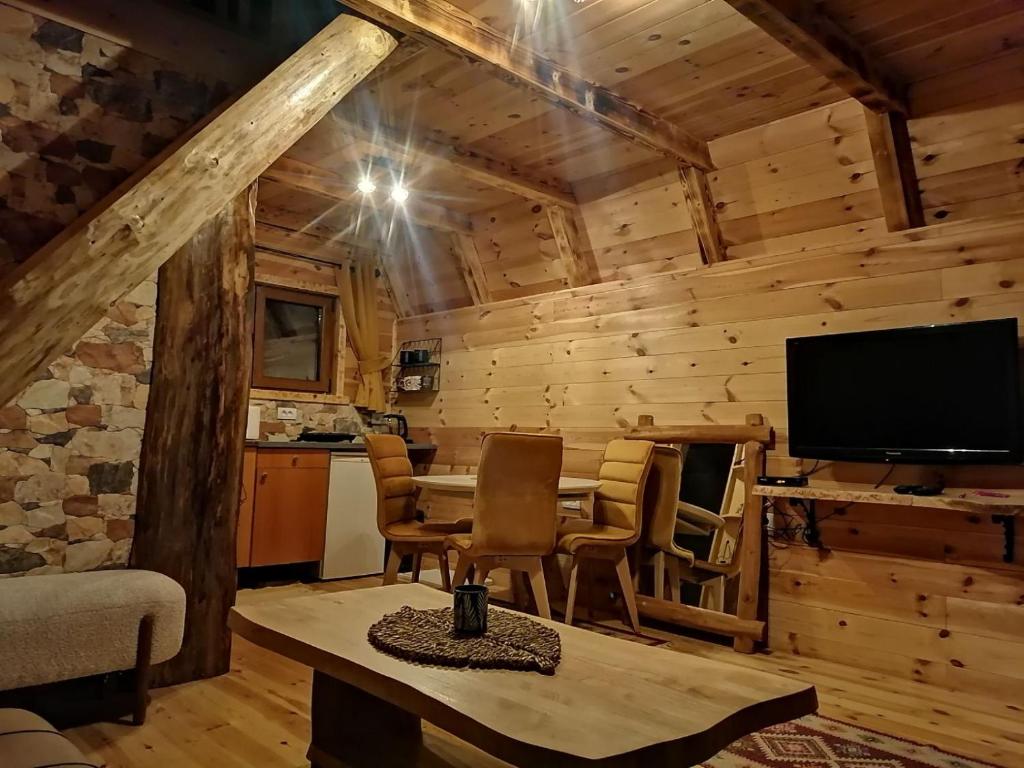 una sala de estar con mesa y TV en una cabina en Koliba Luča Smrčevo Brdo, en Žabljak
