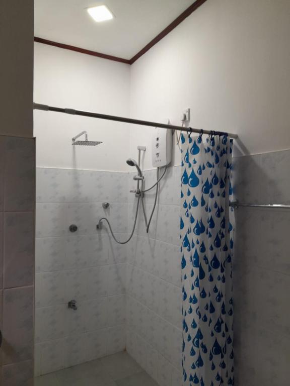 y baño con ducha y cortina azul y blanca. en Sunnyside Bungalow, en Naula