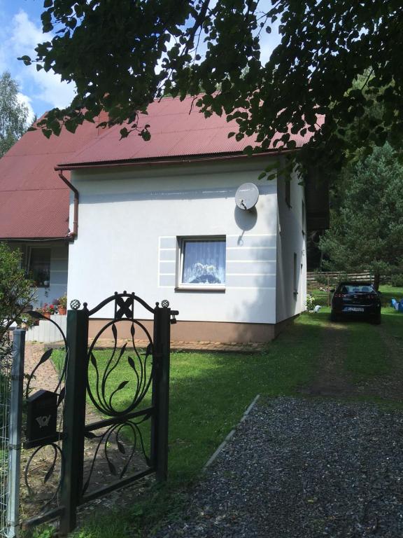 a white house with a gate in front of it at Domek w Glince in Ujsoły