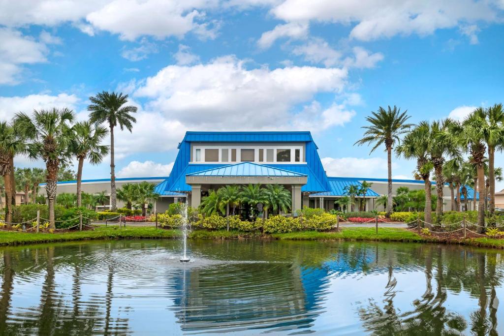 a house with a pond and palm trees at Hilton Vacation Club Aqua Sol Orlando West in Orlando