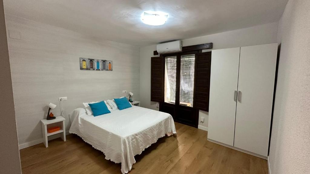 Un dormitorio con una cama con almohadas azules. en Alojamiento Turístico la Moneda de Huecar, en Cuenca
