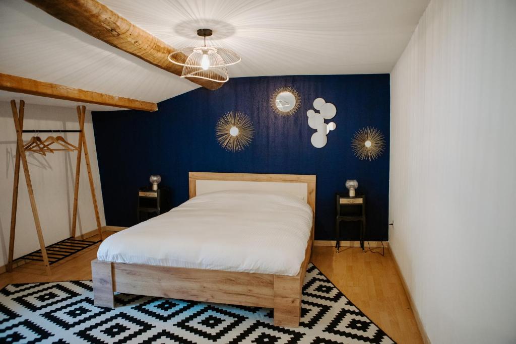 1 dormitorio con 1 cama con pared azul en La maison du fermier, en Solliès-Pont