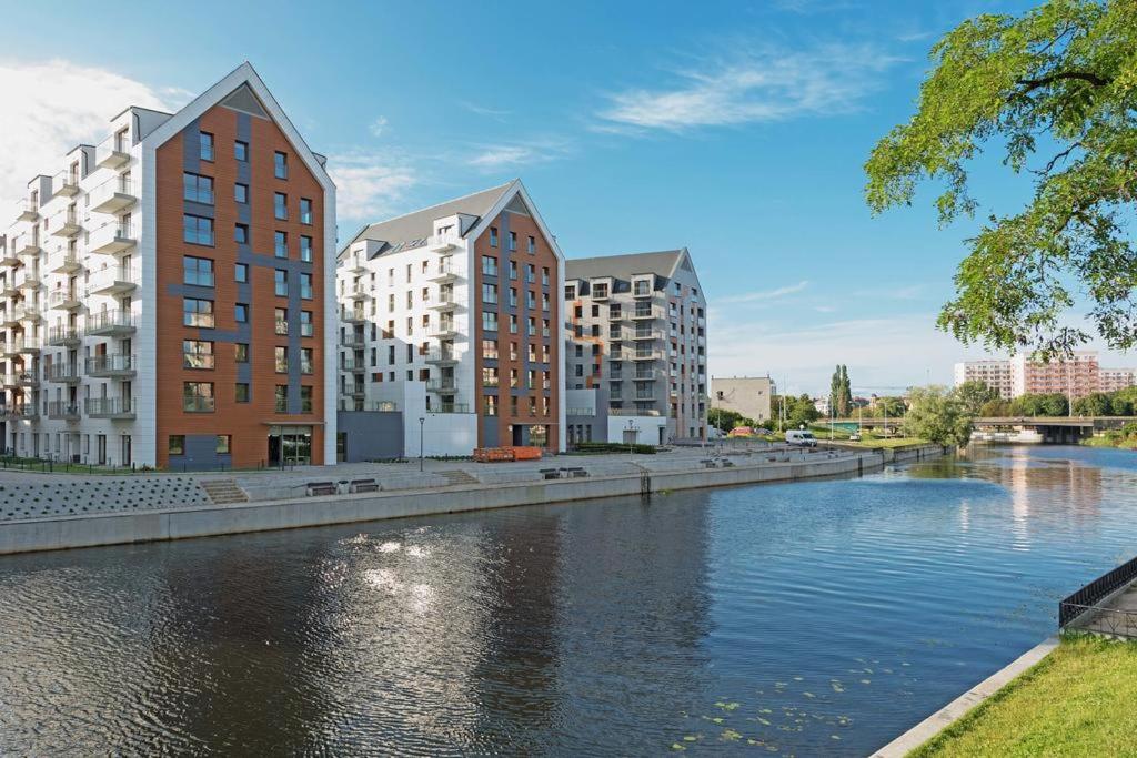 a river in a city with tall buildings and condos at City Center Apartments SPA & Wellness in Gdańsk
