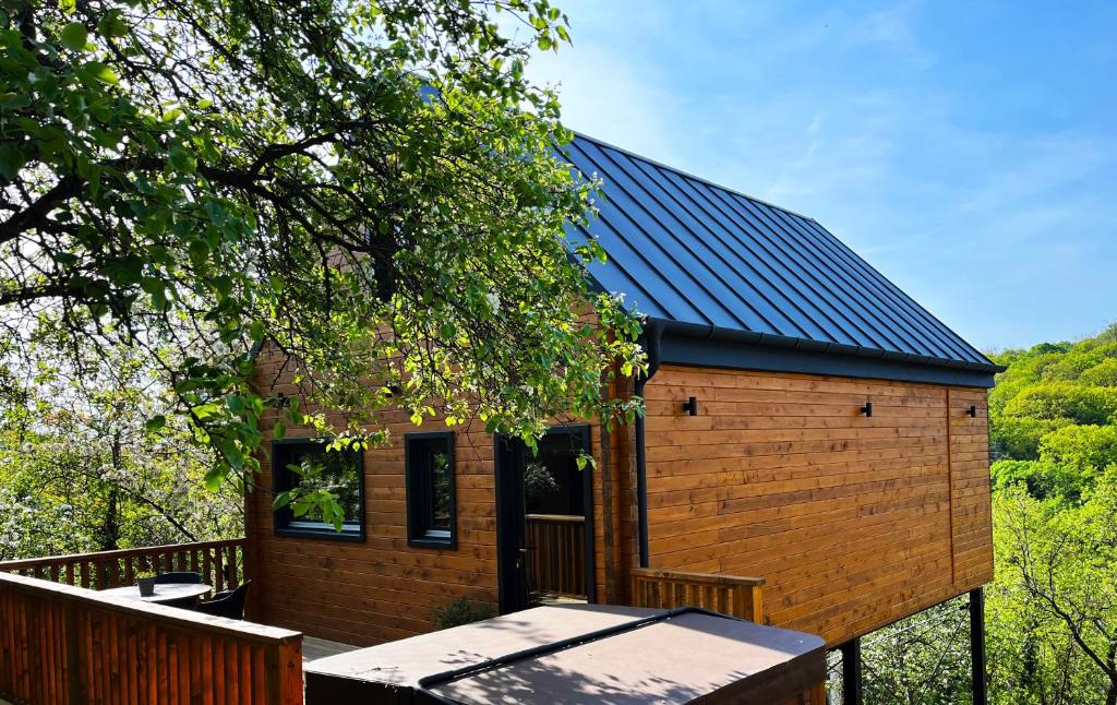 a tiny house with a solar roof on a deck at Woodland Noszvaj in Noszvaj