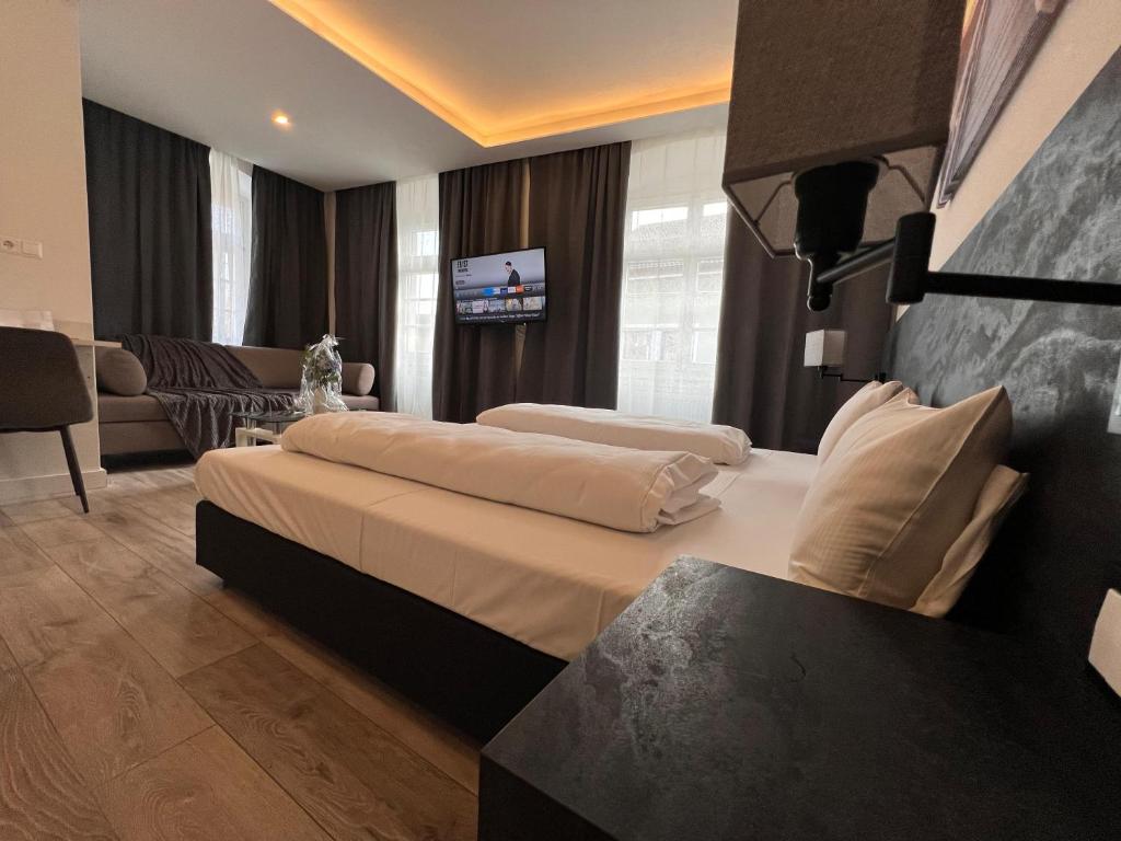 ヴァルツフート・ティンゲンにあるAltstadt Hotel Schwanenのベッドルーム1室(ベッド2台付)、リビングルームが備わります。