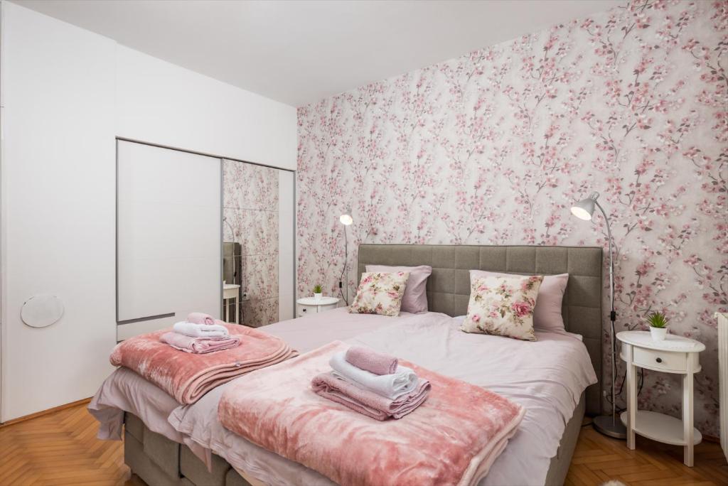 een slaapkamer met 2 bedden met roze bloemenbehang bij Apartman Adriatic in Rijeka