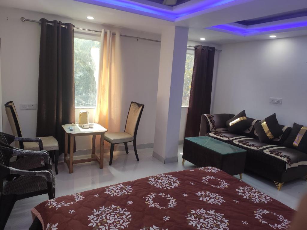 um quarto com uma cama, um sofá e uma mesa em Hotel Partap Inn em Nova Deli