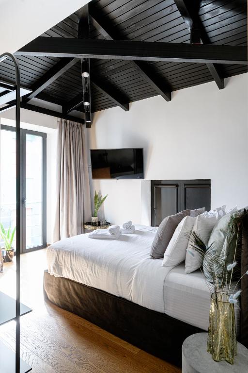 a bedroom with a large bed with white sheets at Mamy Blue Slow Living in Athens