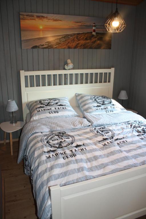 a bed with a blue and white comforter in a bedroom at Us nige Wark - Familienfreundliches Haus an der Nordsee in Spieka-Neufeld