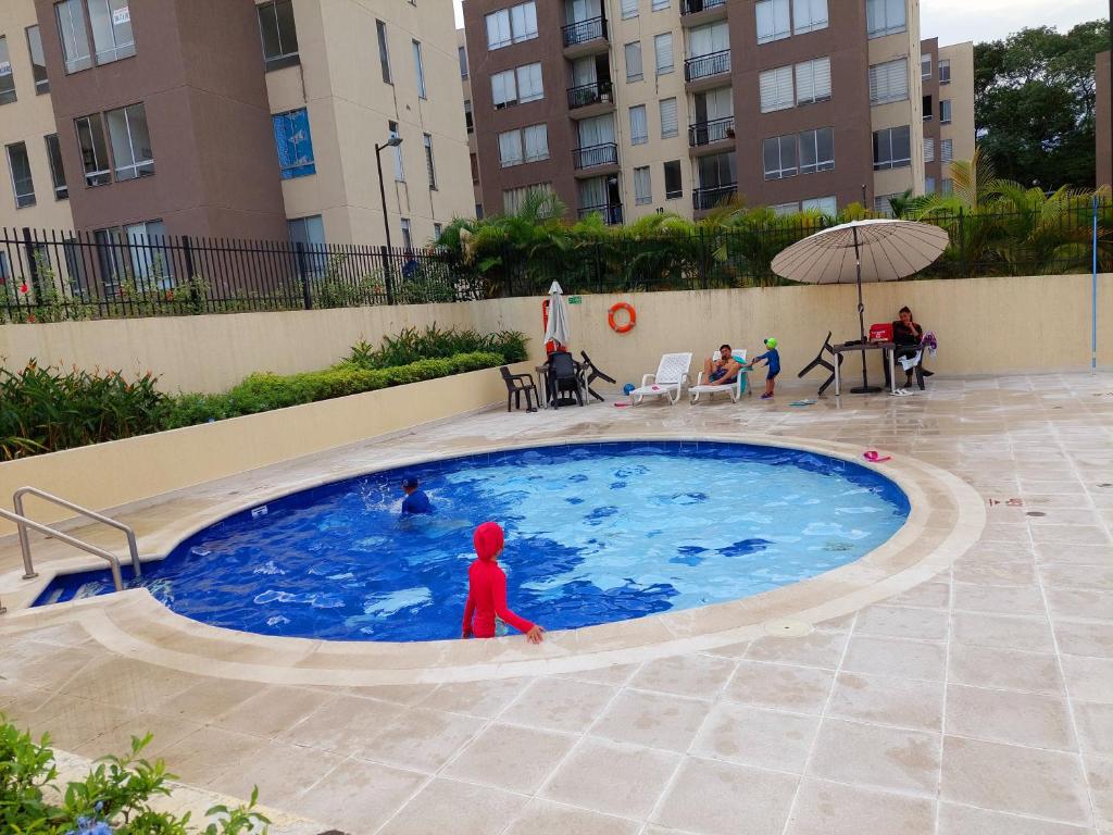 un enfant se tient debout dans une piscine dans l'établissement Apartamento en condominio con piscina, à Villavicencio