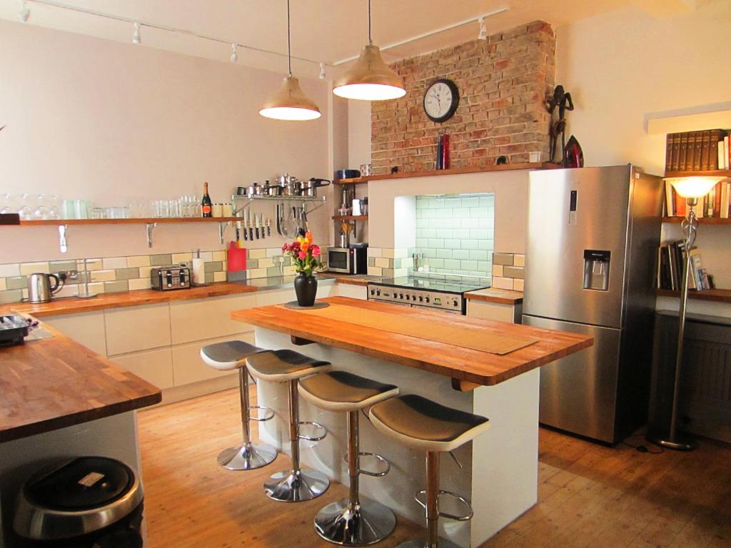 a kitchen with a wooden counter and a refrigerator at Designer Maisonette Whole Apartment in Brighton & Hove