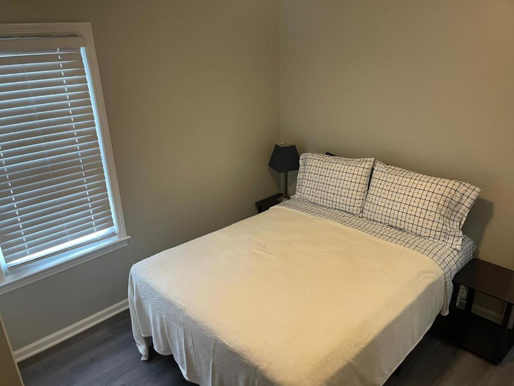 niewielka sypialnia z łóżkiem i oknem w obiekcie Room near the beach in long branch w mieście Long Branch