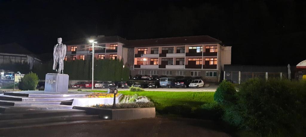 a building at night with a statue in front of it at Jezero in Nova Varoš