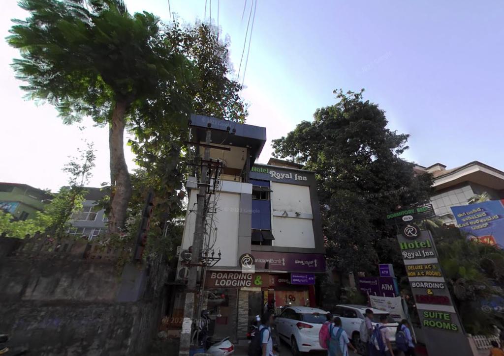 una calle con una palmera y un edificio en Hotel Royal Inn Mangalore - Opp SDM Law College MG Road, en Mangalore