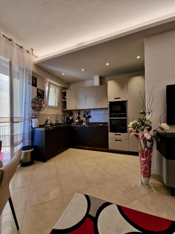 a large kitchen with a vase of flowers on the floor at Novoli Chic: Cuore di Firenze in Florence