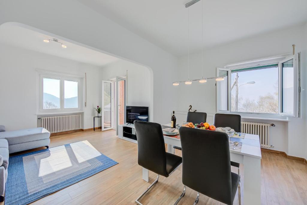 una sala de estar blanca con mesa y sillas en Ca' Gina Panoramica, en Lugano