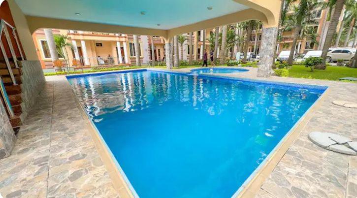 una gran piscina azul en una casa en Bahama scape, en Dar es Salaam