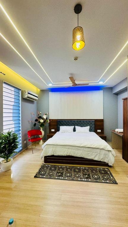 Star Comfort Inn في لاكناو: غرفة نوم بسرير كبير وكرسي احمر