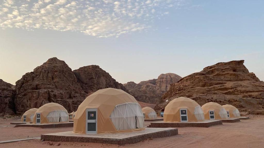 a group of tents in the desert with rocks at Wadi Rum palace in Wadi Rum