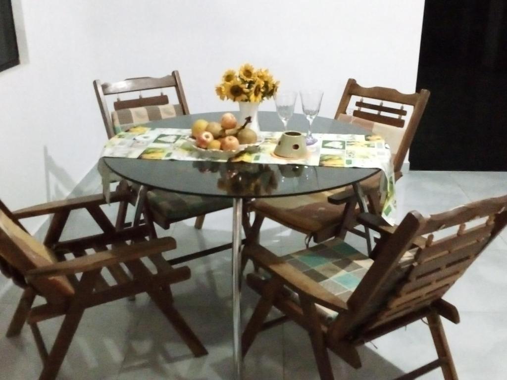 a glass table with chairs and a bowl of fruit on it at Casa de Amigos in Samaipata