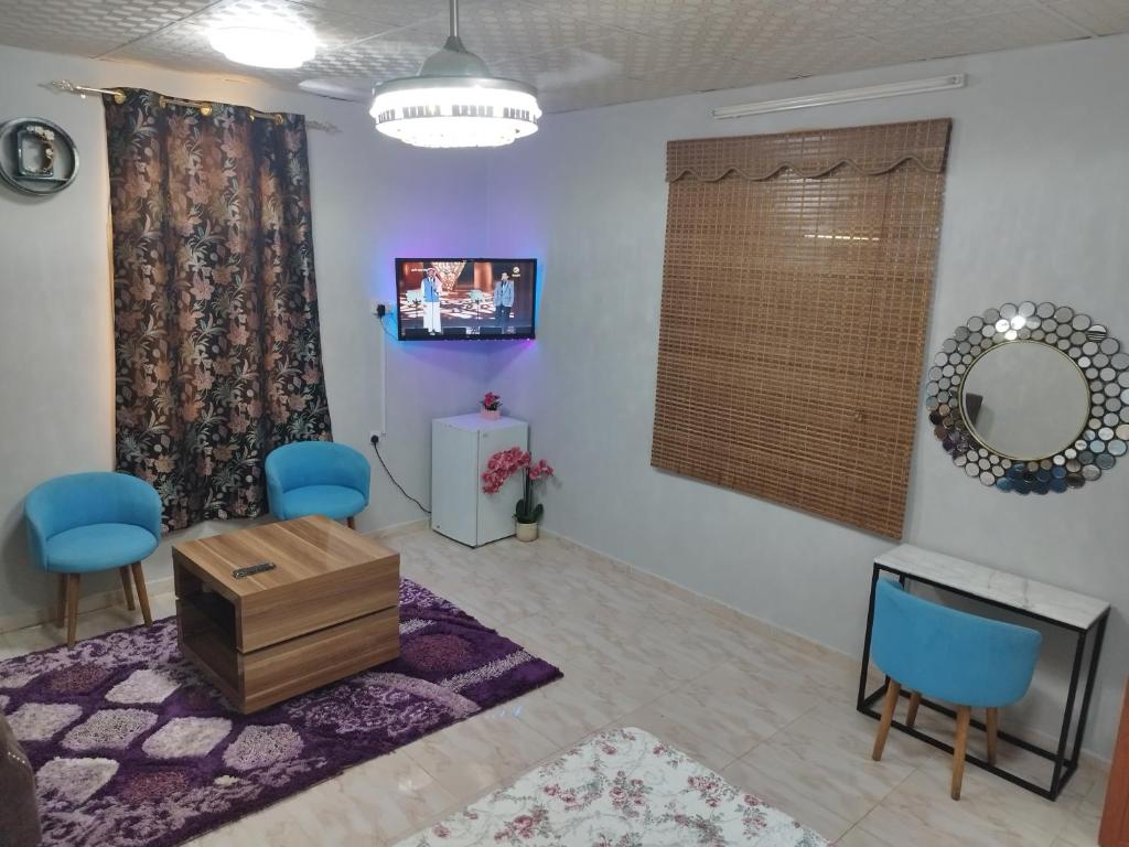 een woonkamer met blauwe stoelen en een spiegel bij منزل صحم in Al Quşayr