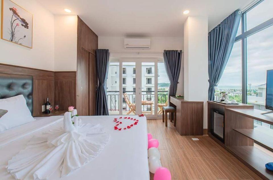 芽莊的住宿－Marilla Nha Trang Hotel - by Bay Luxury，一间带白色大床的卧室和一间厨房