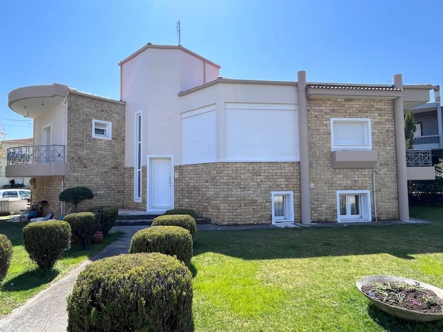 a large brick building with bushes in a yard at Mama's house. 300m απο τον μύλο των ξωτικών. in Tríkala