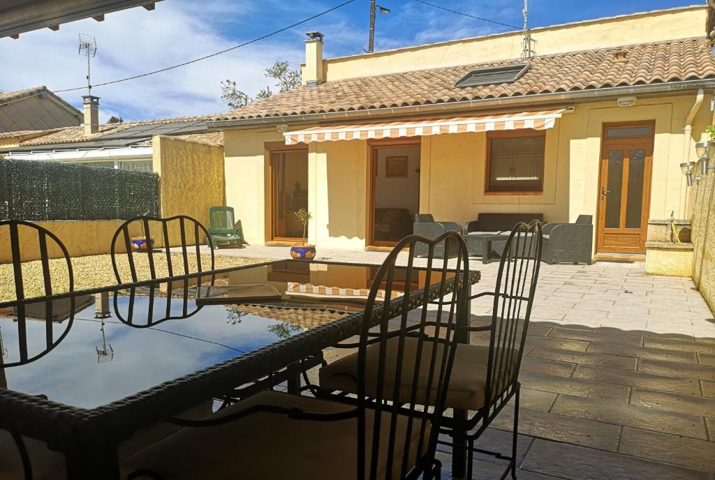 un patio avec des chaises et une table devant une maison dans l'établissement '' la crossette '' Charmante maison dans quartier calme, à Béziers