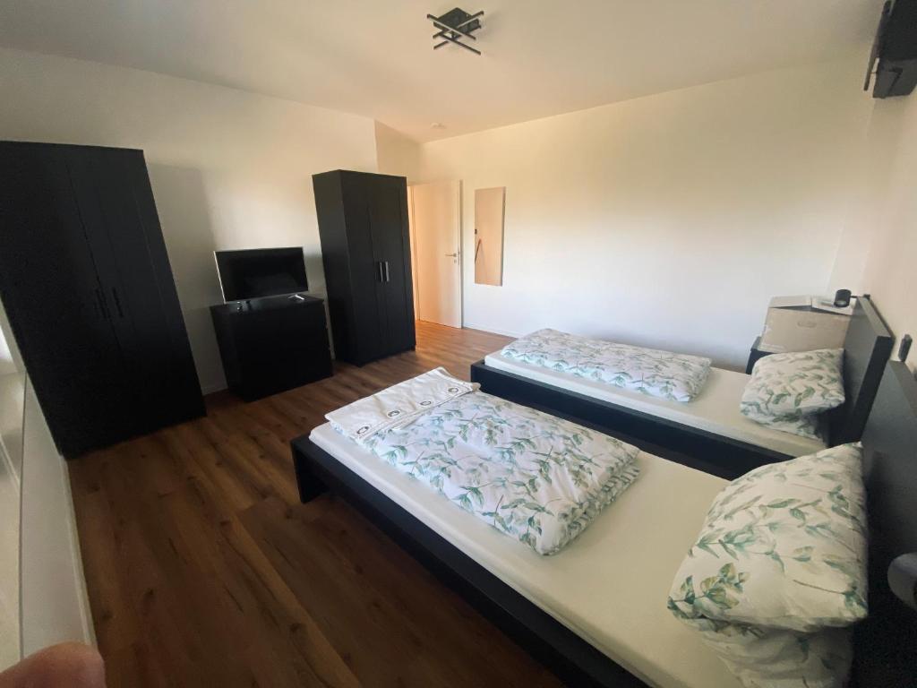 een kamer met 2 bedden en een tv. bij Montihaus Gäste & Monteurzimmer in Dormagen