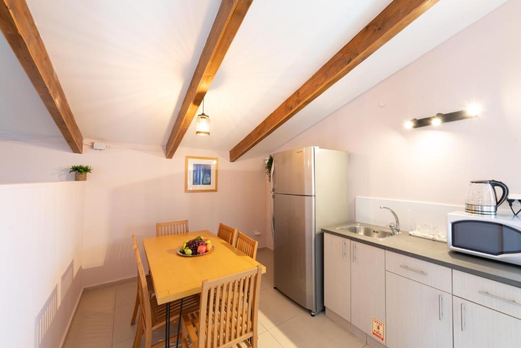 a kitchen with a table and a refrigerator at Villa Li Eilat in Eilat