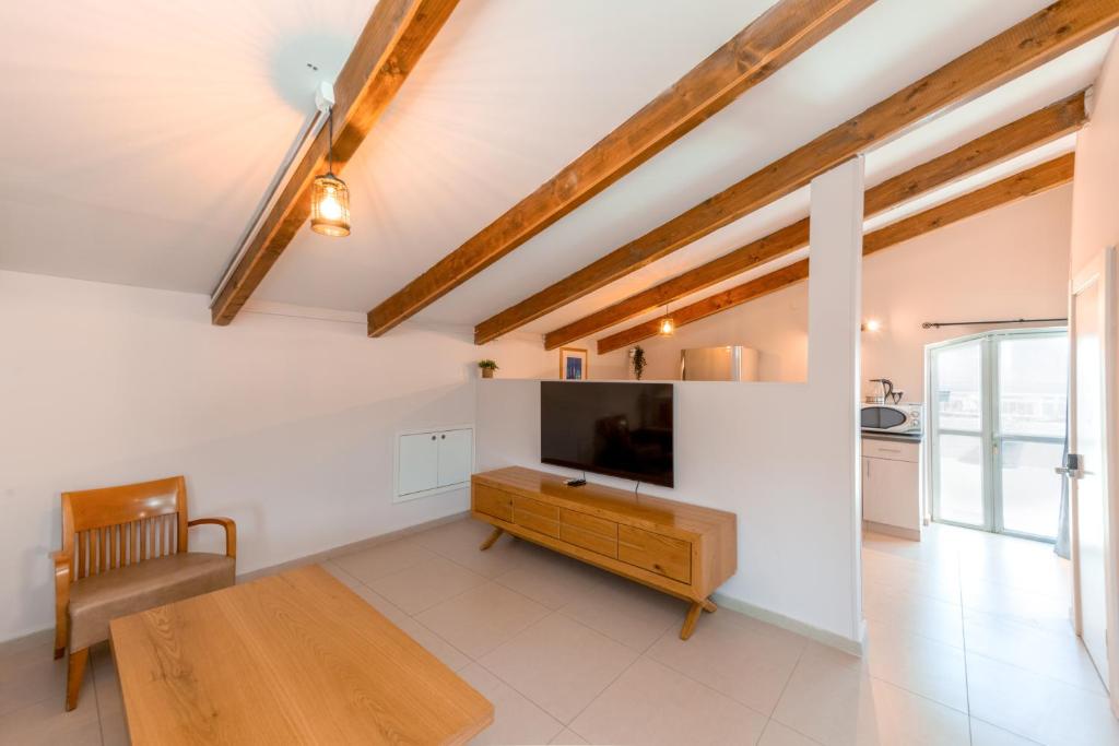 a living room with a television and a table at Villa Li Eilat in Eilat
