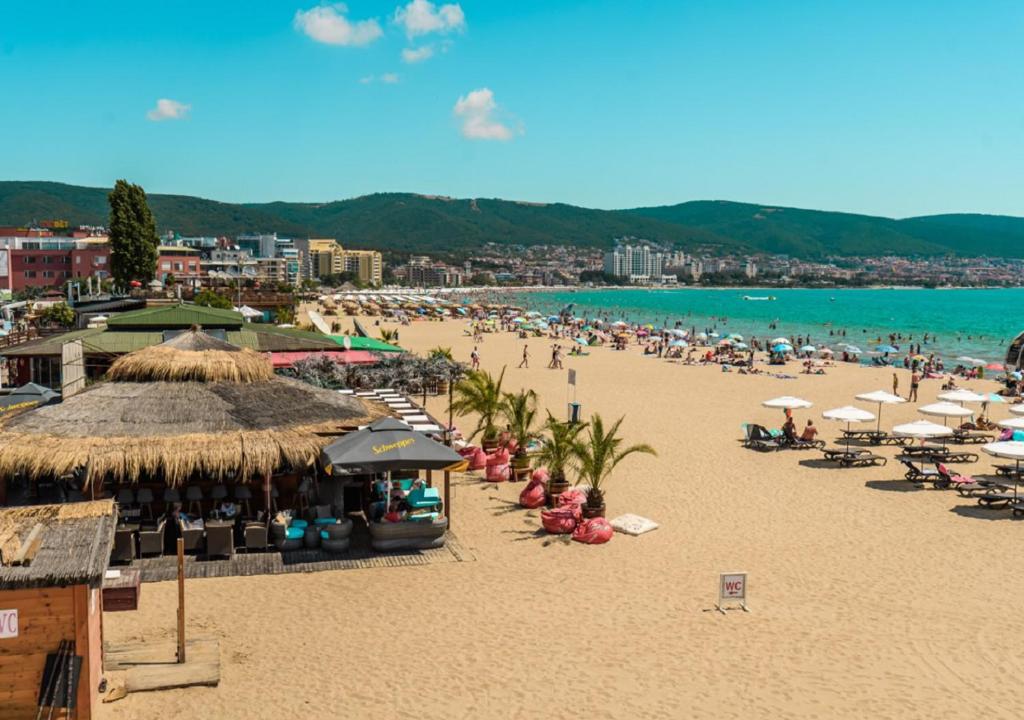 a beach with a lot of people and umbrellas at Charis Cozy Family apart at Sun Village Complex close to the Beach in Sunny Beach