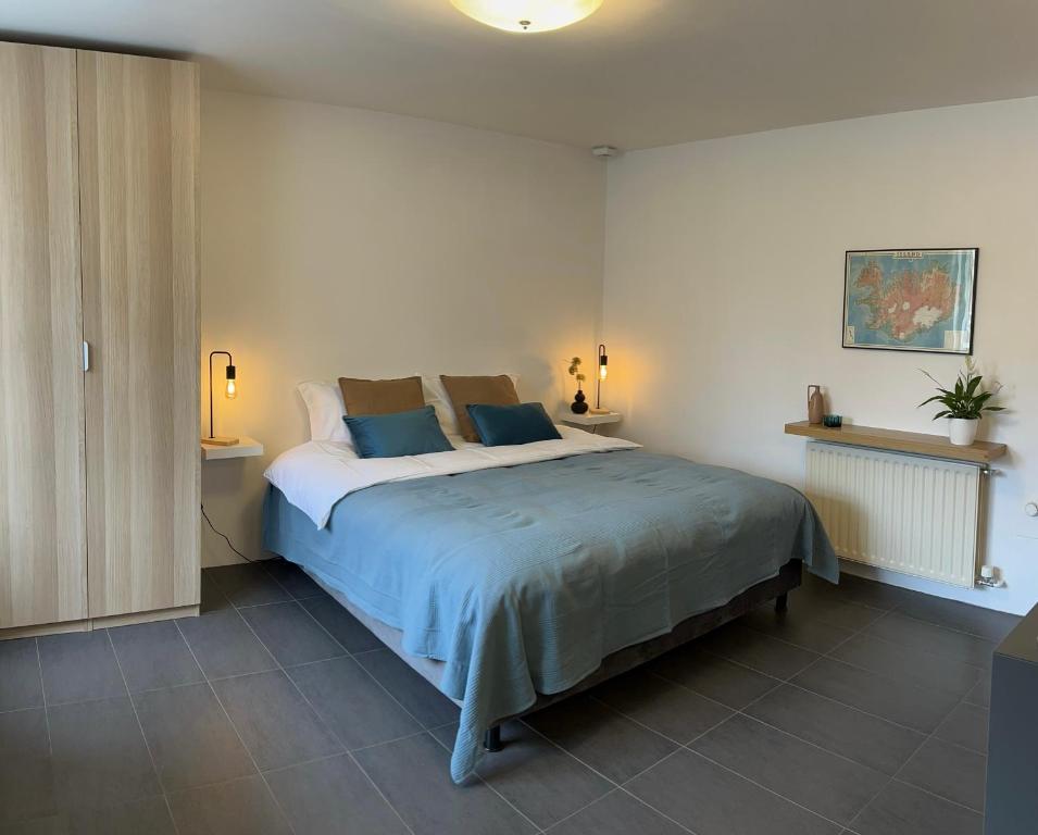 1 dormitorio con 1 cama grande con almohadas azules en Reykjavik city center - Privat studio apartment, en Reikiavik