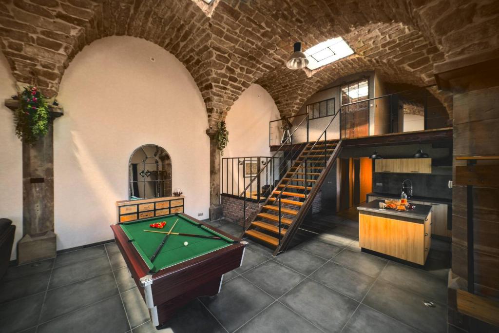 a room with a pool table and a spiral staircase at La Chapelle Industrielle in Issenheim