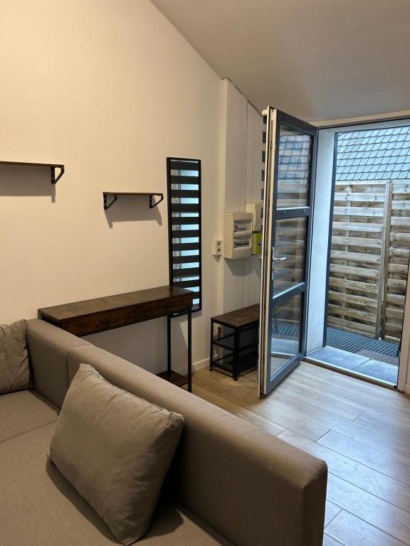 a living room with a couch and a large window at Grand Place Roubaix Appartement Style Loft in Roubaix