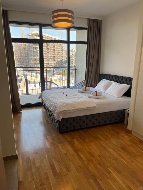 a large bed in a room with a large window at Angel BW Apartments in Sajmište