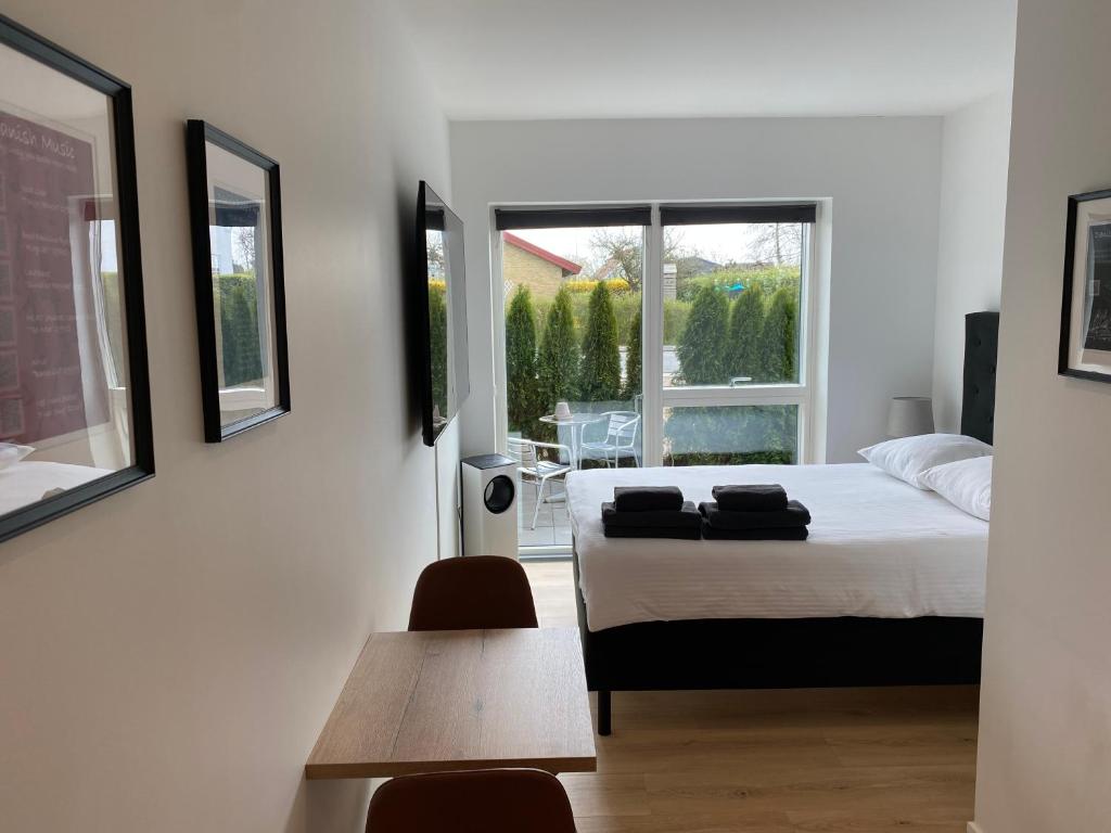a bedroom with a bed and a table and a window at CPH Like Home in Copenhagen