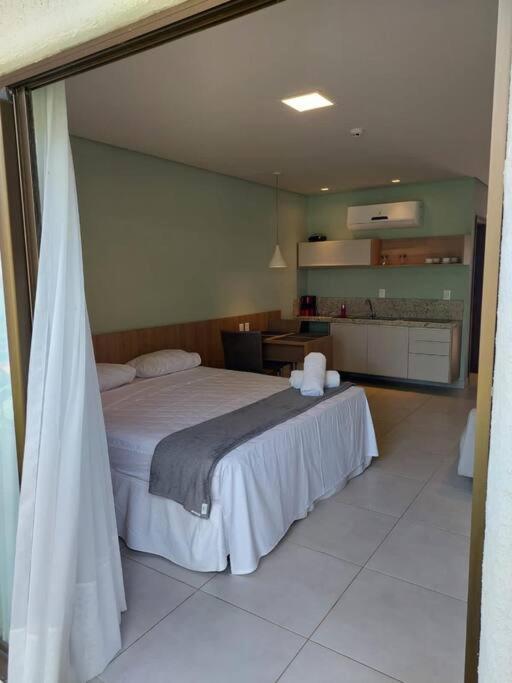 um quarto com uma cama grande e uma cozinha em Apto no Villas BobZ - Barra Grande em Cajueiro