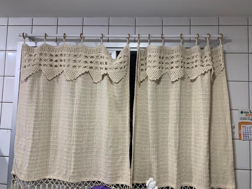 cortina de ducha colgada sobre una barra en el baño en Encanto Guarapari, en Guarapari