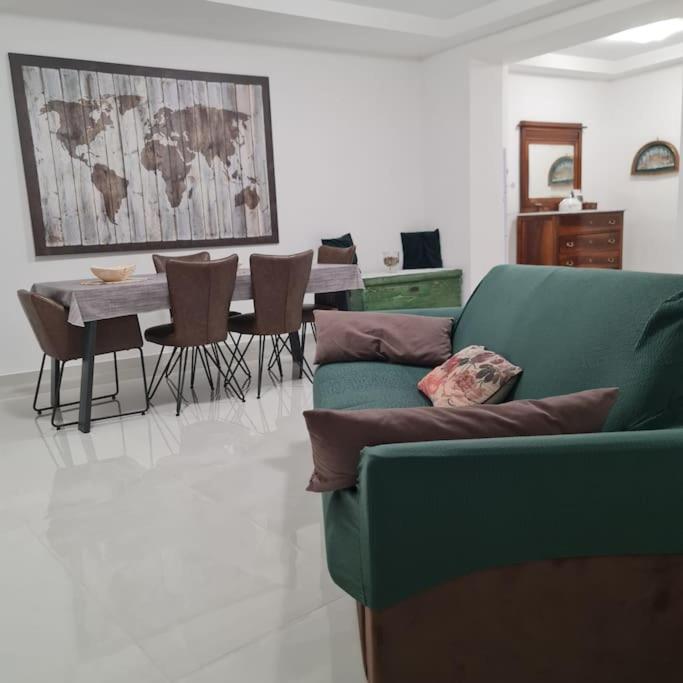 ein Wohnzimmer mit einem Sofa und einem Tisch mit Stühlen in der Unterkunft La Bella Dimora in città in Castellammare di Stabia