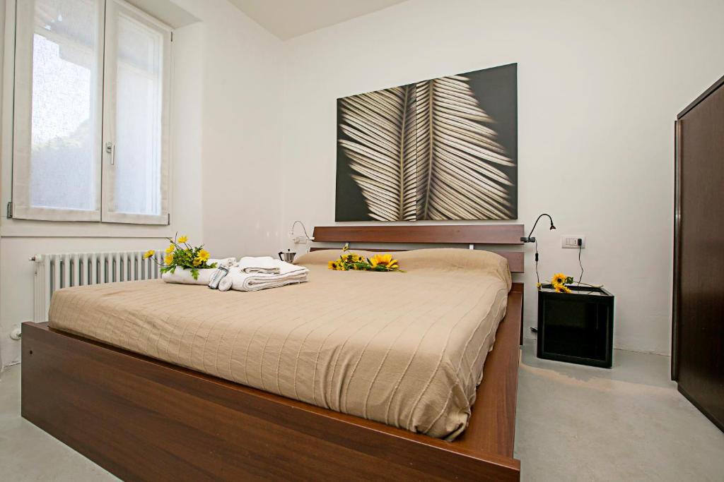 sypialnia z łóżkiem z żółtymi kwiatami w obiekcie Casa Alla Grotta - Happy Rentals w Arco