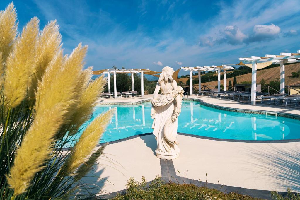 uma estátua em frente a uma piscina em Boutique Hotel Casa Grimaldi em Matelica