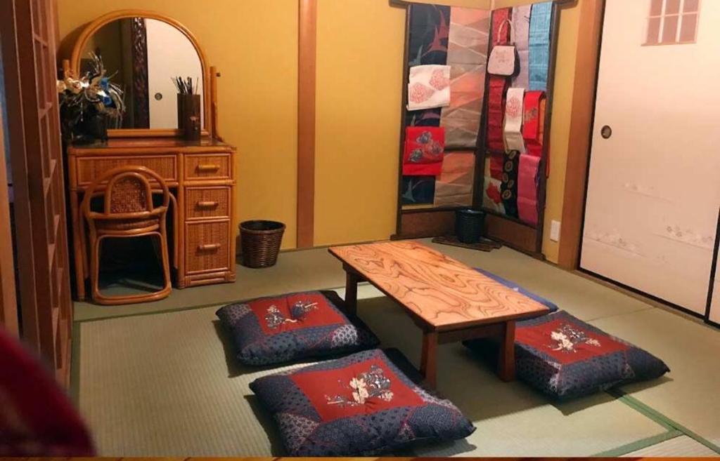 salon ze stołem i 2 otomanami w obiekcie 百合の家 w mieście Kioto