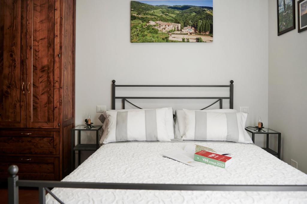Un dormitorio con una cama con un libro. en Castellinuzza, en Greve in Chianti