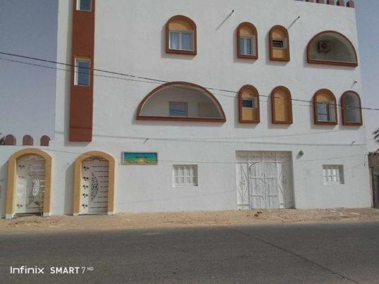 a large white building with doors and windows at Résidences Porte de désert Douz in Douz